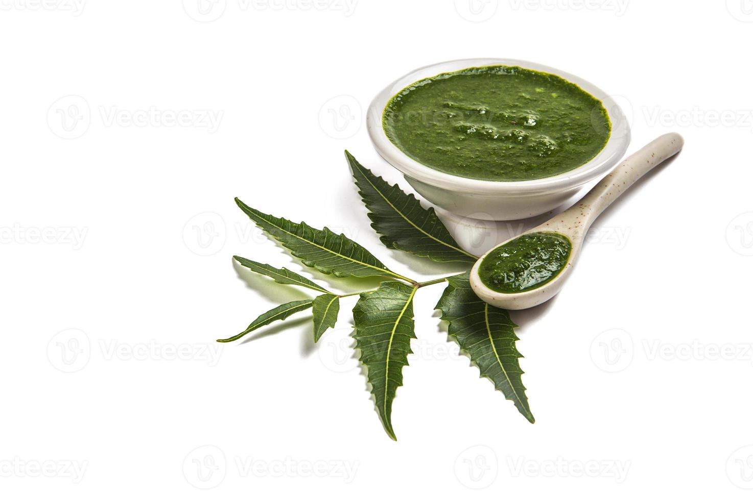 Hojas de neem medicinales con pasta de neem en cuchara y plato sobre fondo blanco azadirachta indica foto