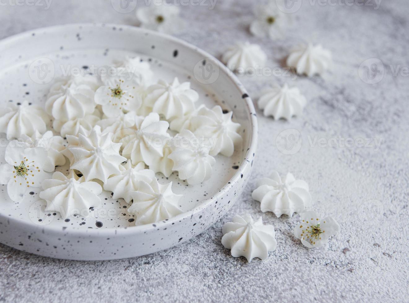 Small white meringues in the  ceramic bowl photo