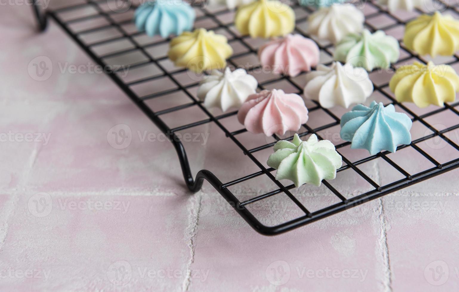 Multicolored meringue on a baking rack photo