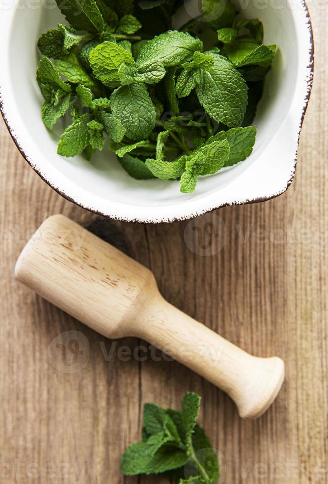 Fresh green mint leaves in mortar photo