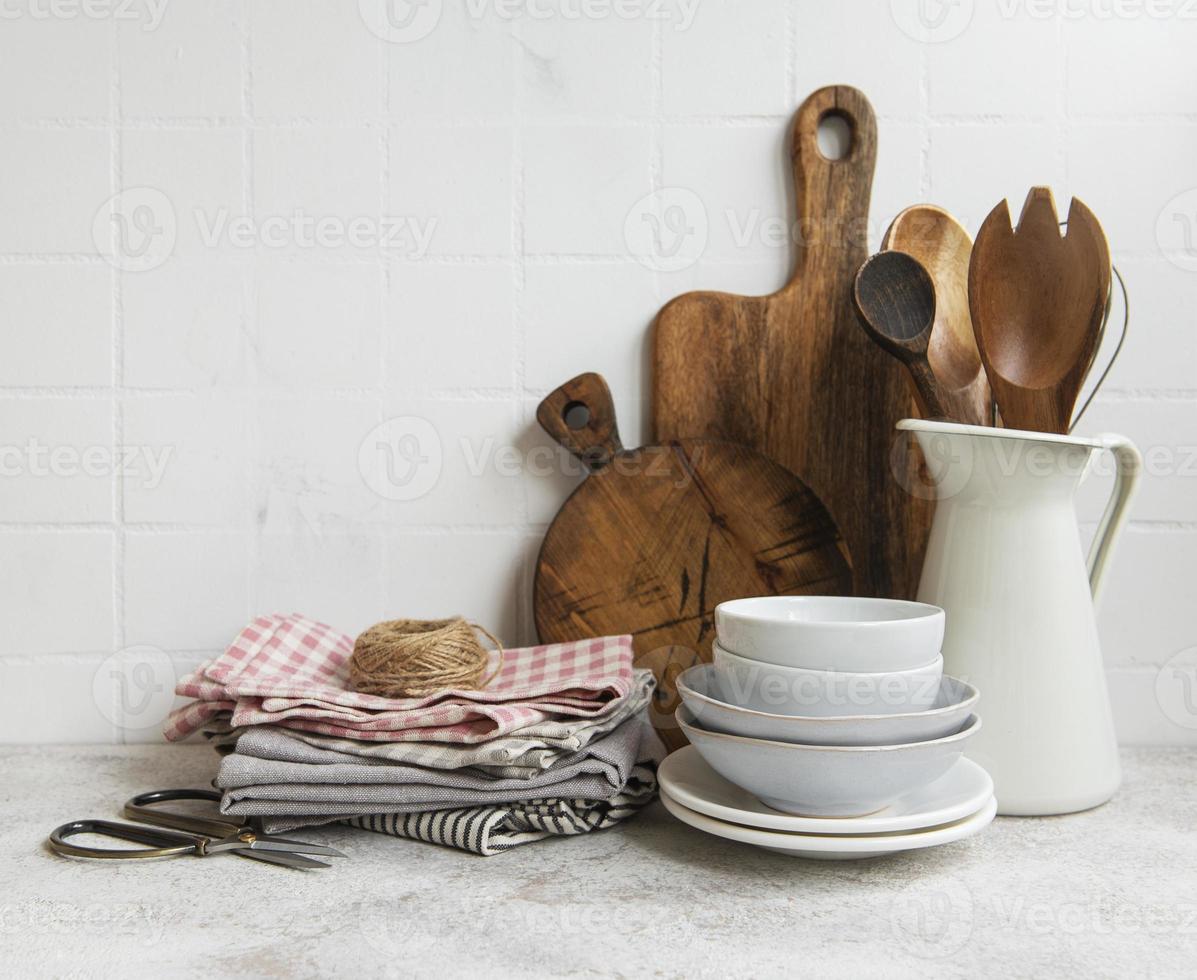 utensilios de cocina, herramientas y vajilla en la pared de azulejos blancos de fondo. foto