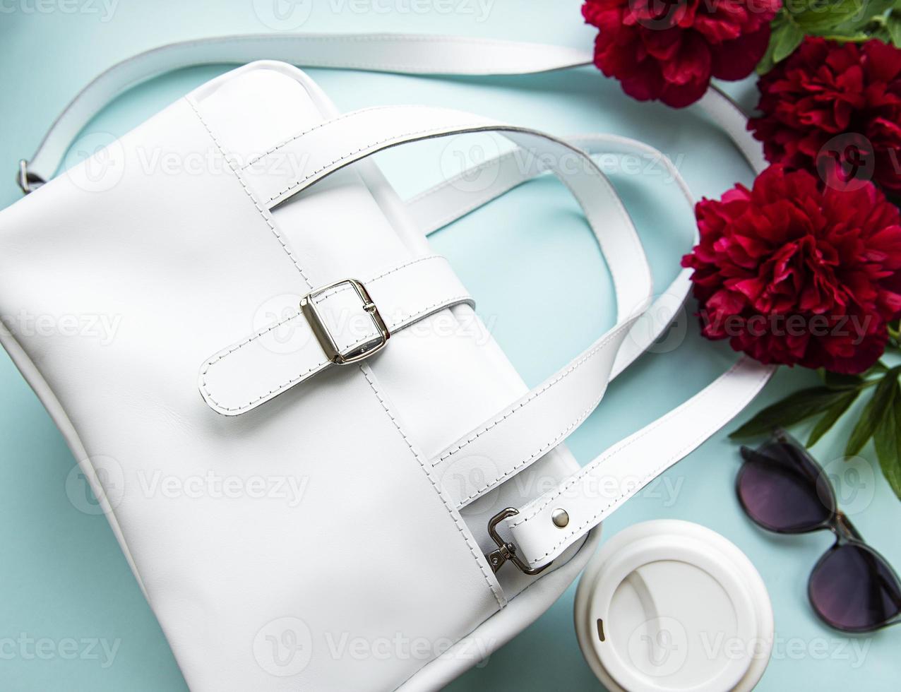 White leather bag and peony flowers photo