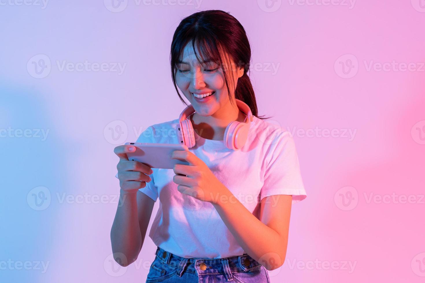 joven asiática jugando en el teléfono con emoción foto