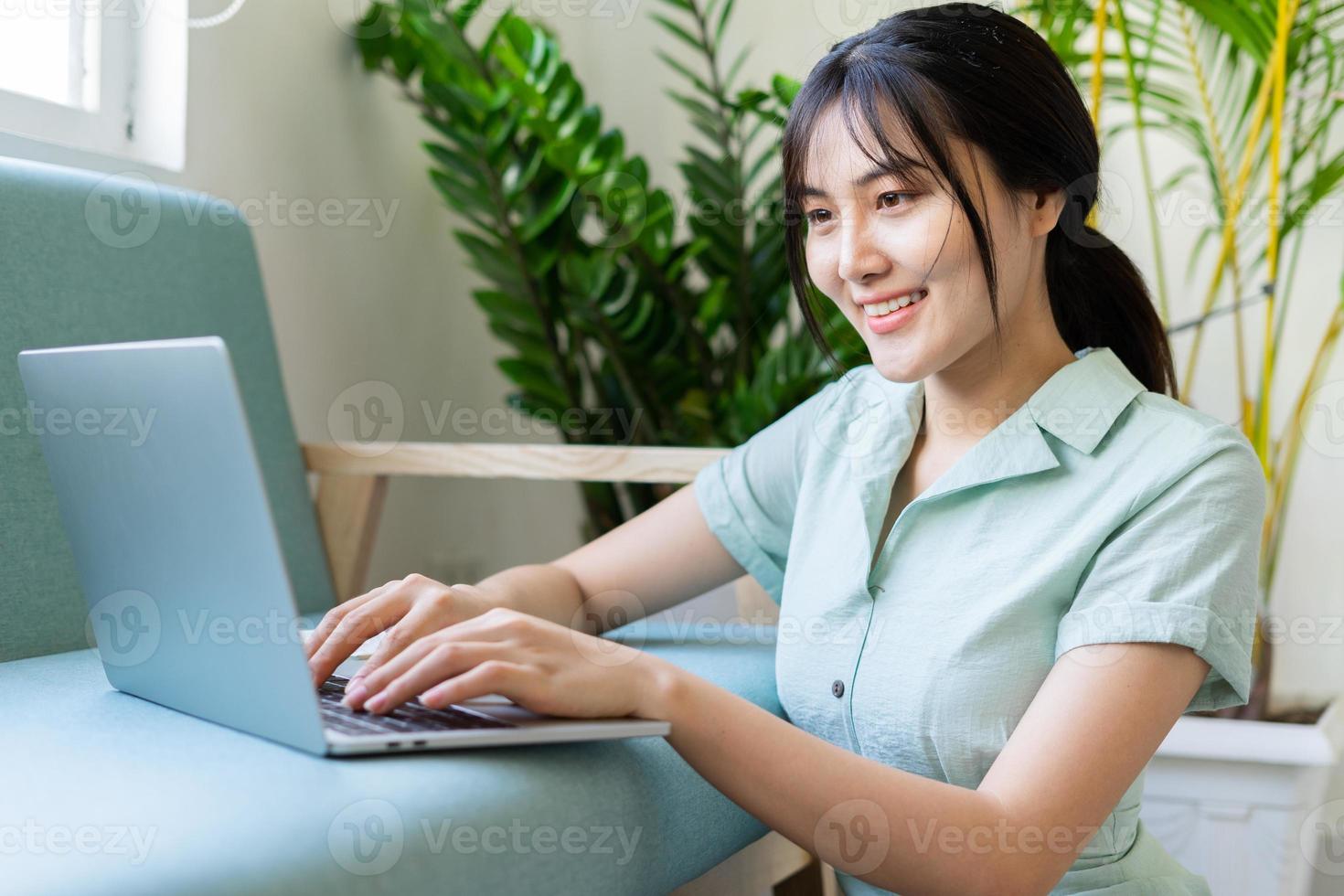 joven mujer asiática que trabaja en línea desde casa foto