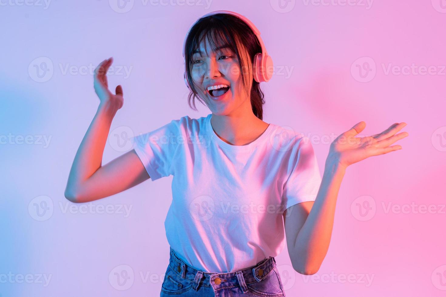 joven asiática está usando audífonos y escuchando música con entusiasmo foto