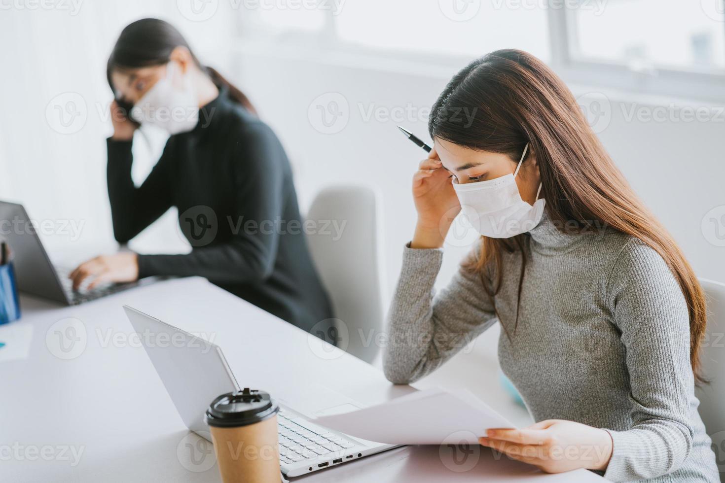 dos mujeres deben usar máscaras durante las horas de trabajo para mantenerse seguras durante las epidemias foto