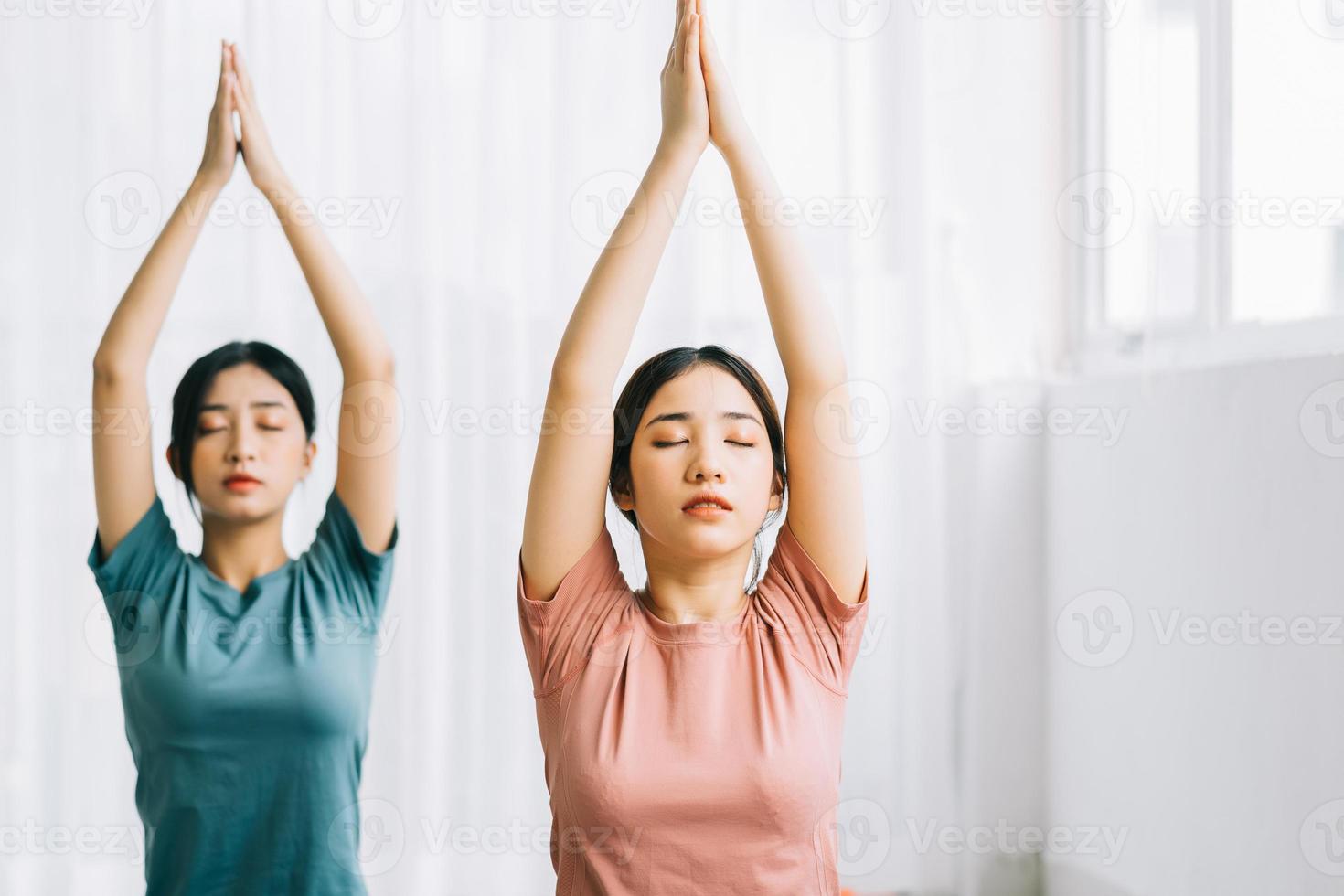 Two Asian women are practicing meditation at home photo