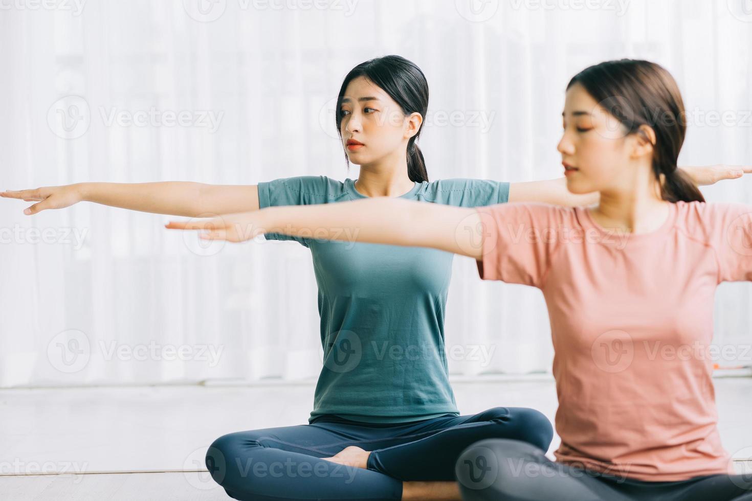 dos mujeres asiáticas están practicando meditación en casa foto