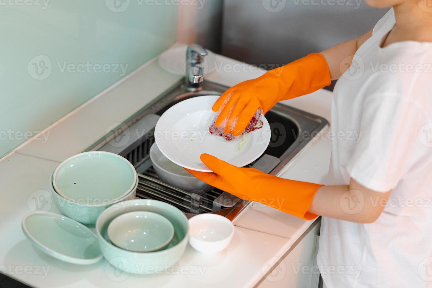 la mujer asiática está lavando los platos foto