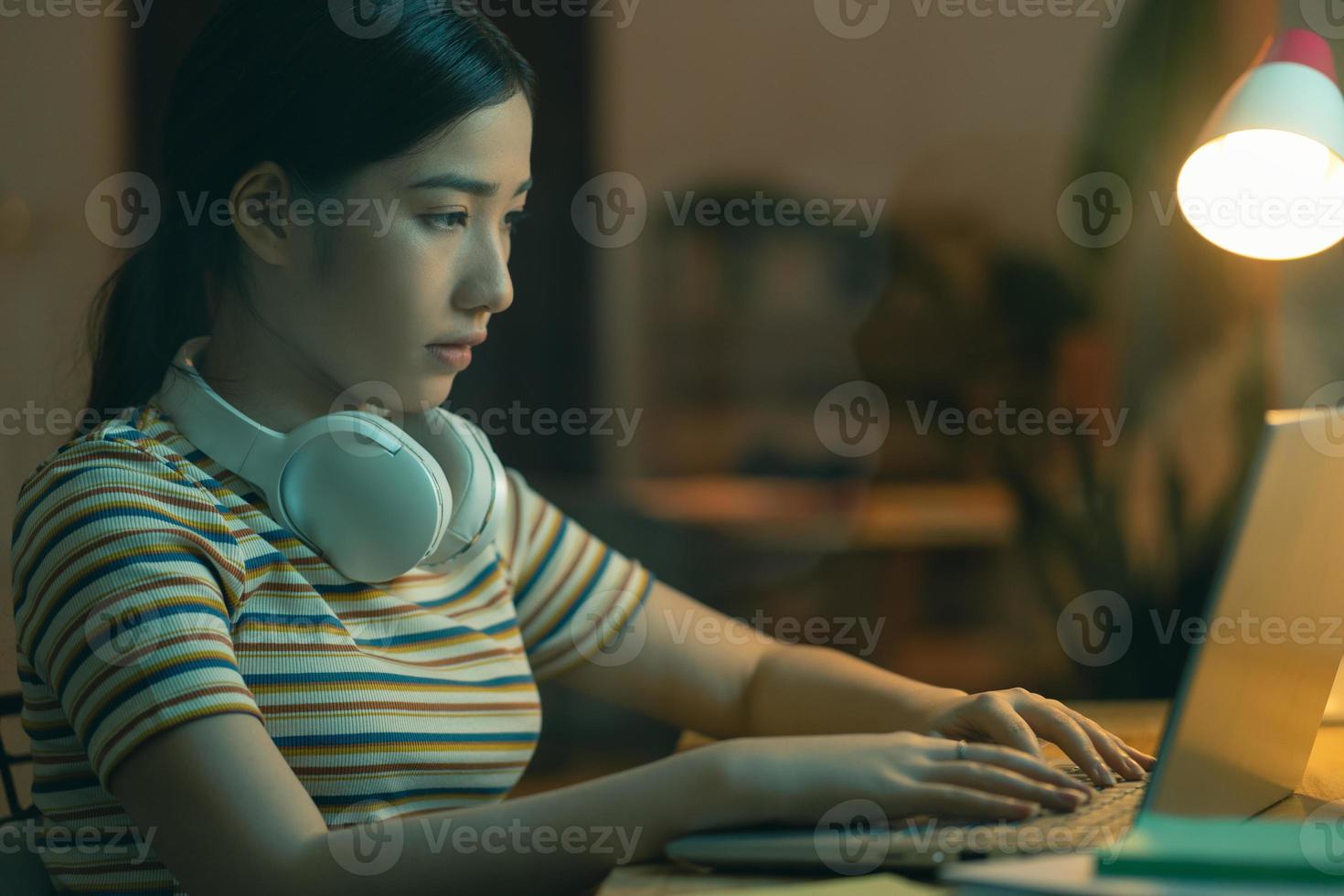 Hermosa mujer asiática tratando de terminar el trabajo por la noche foto