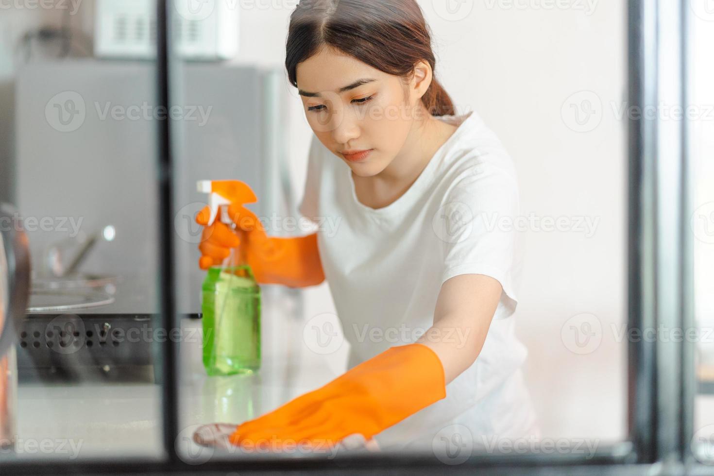 Beautiful Asian woman cleaning the kitchen area photo