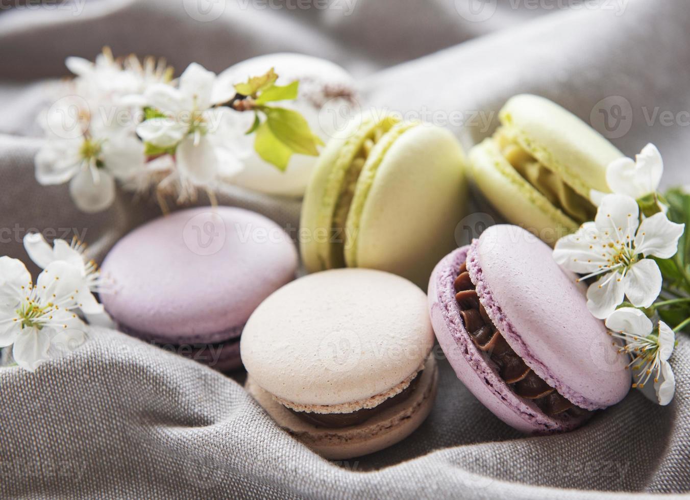 Macarrones dulces franceses variedad colorida sobre un fondo gris textil foto