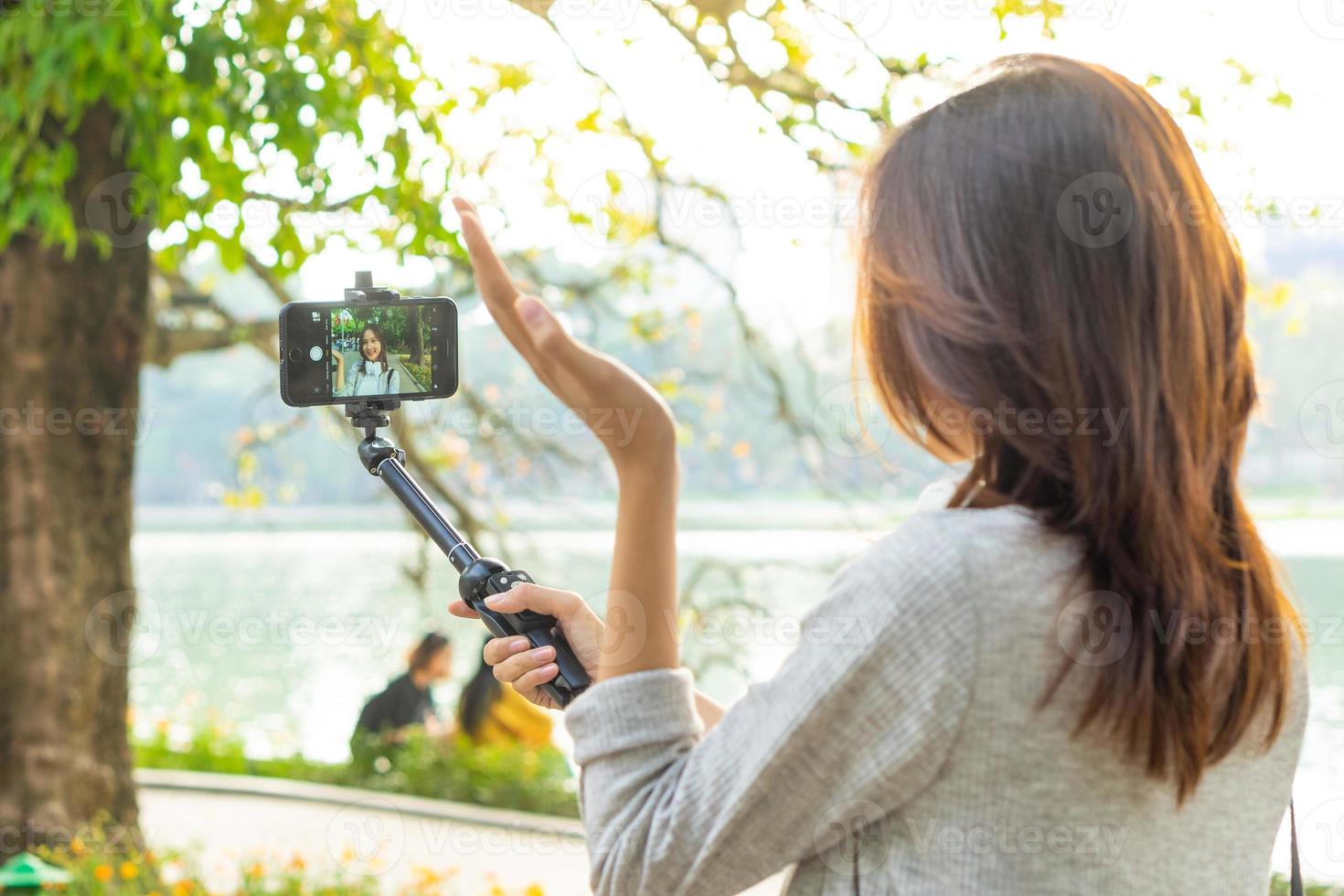 Mujer asiática grabando video en la calle en Hanoi, Vietnam foto