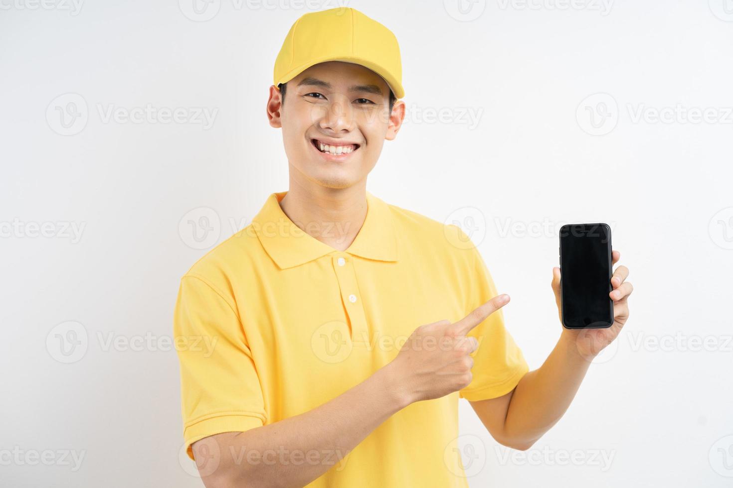 An Asian man in a yellow uniform was pointing at the cell phone in his hand photo