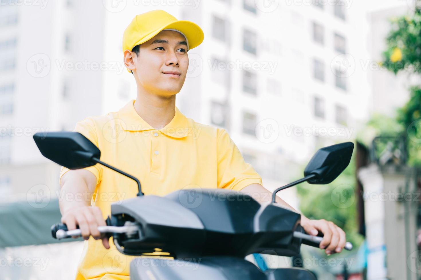 Asian delivery person is driving his motorcycle to deliver to customer photo