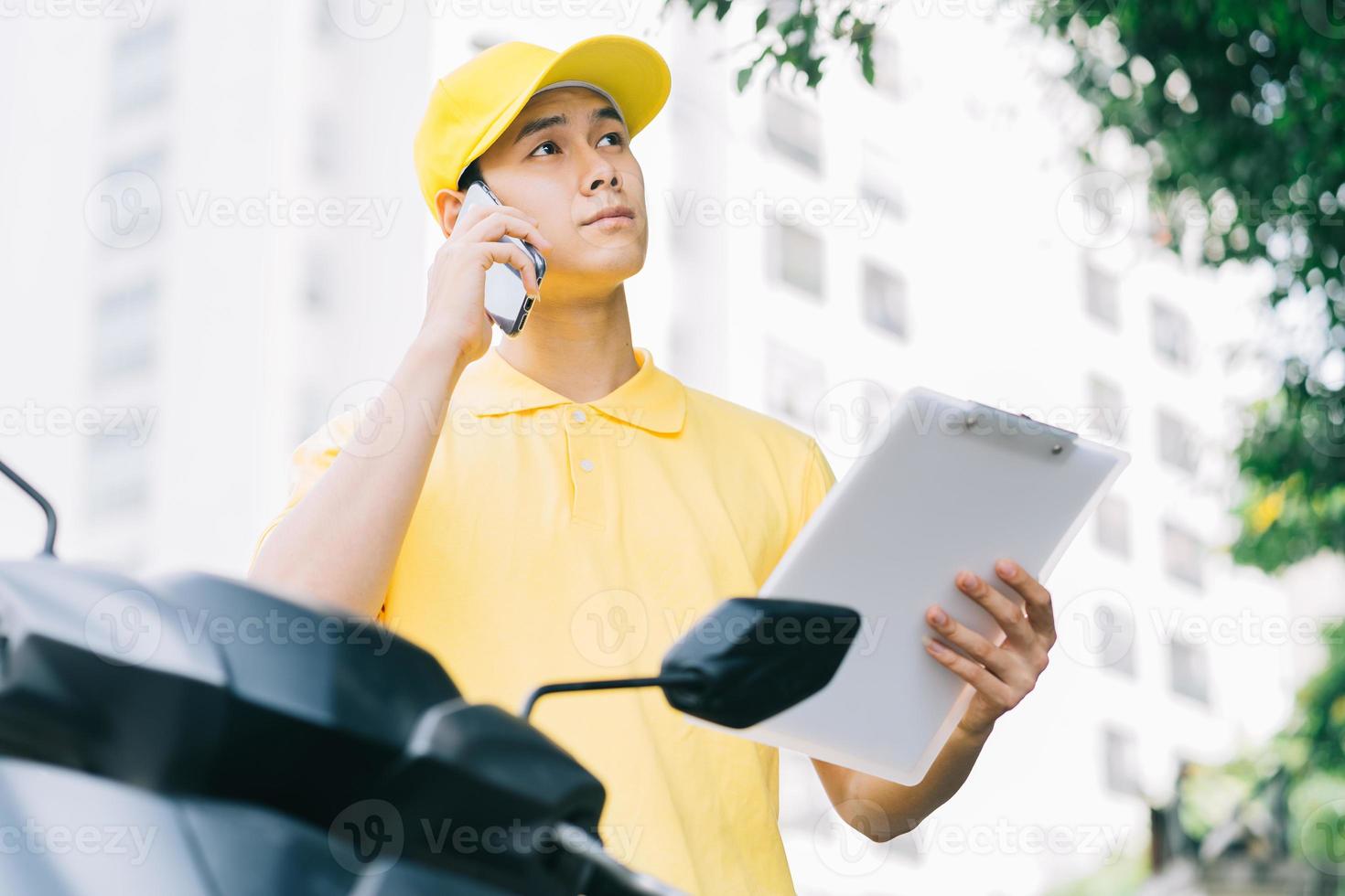 El remitente asiático está llamando al cliente para obtener los productos. foto