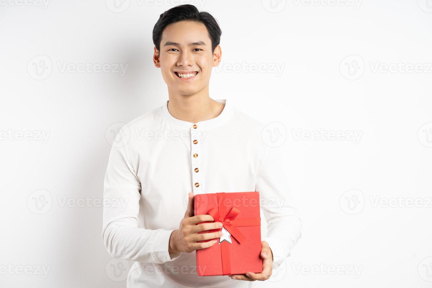 Asian businessman is holding red gift box on white background photo