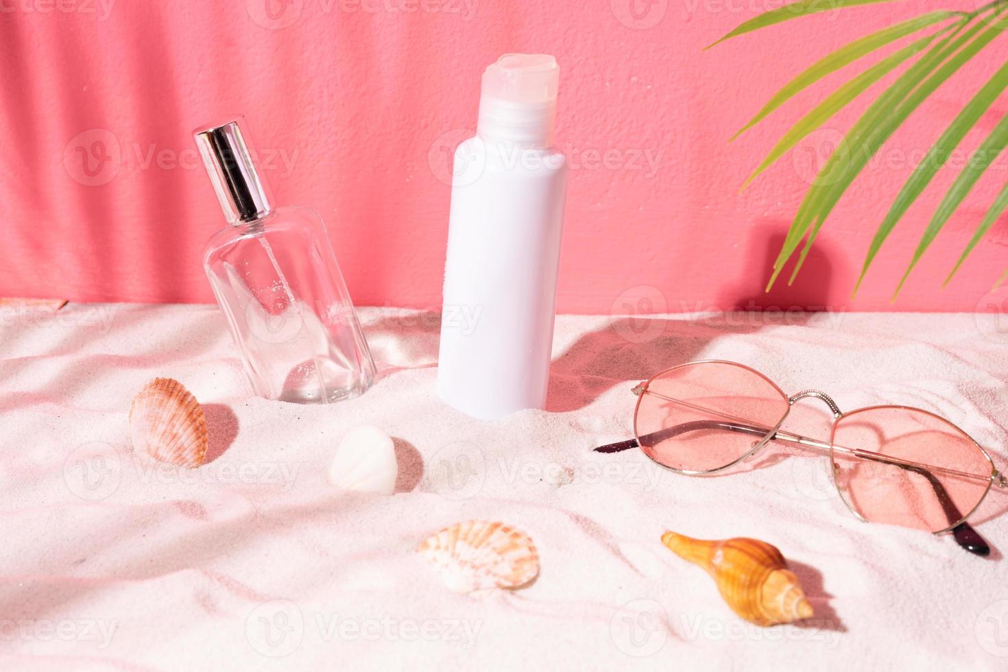 Empty cosmetic jar decorated in the sand with seashells around photo