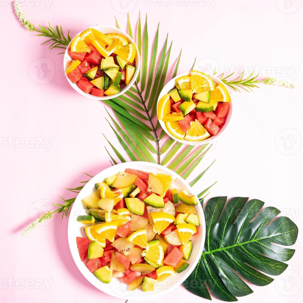 Chopped tropical fruit in bowls and plates photo