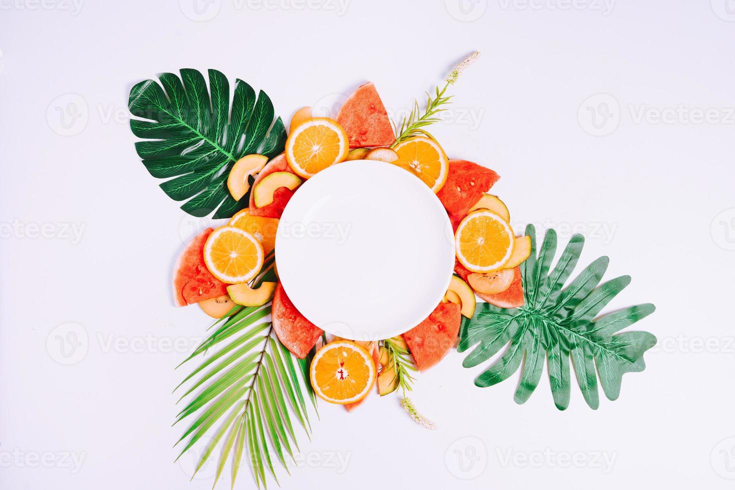 el plato vacío se coloca sobre trozos de fruta tropical foto