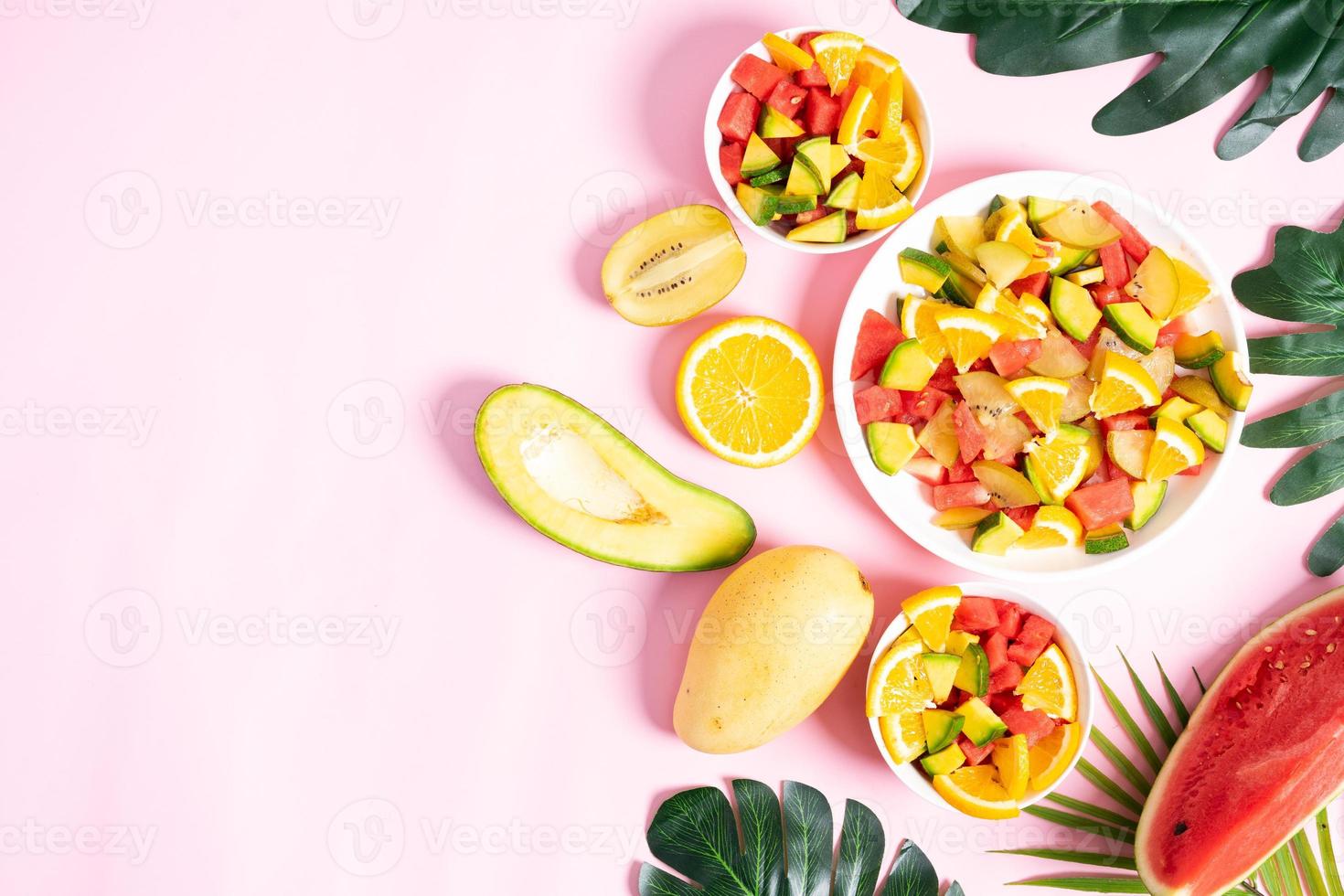 Chopped tropical fruit in bowls and plates photo