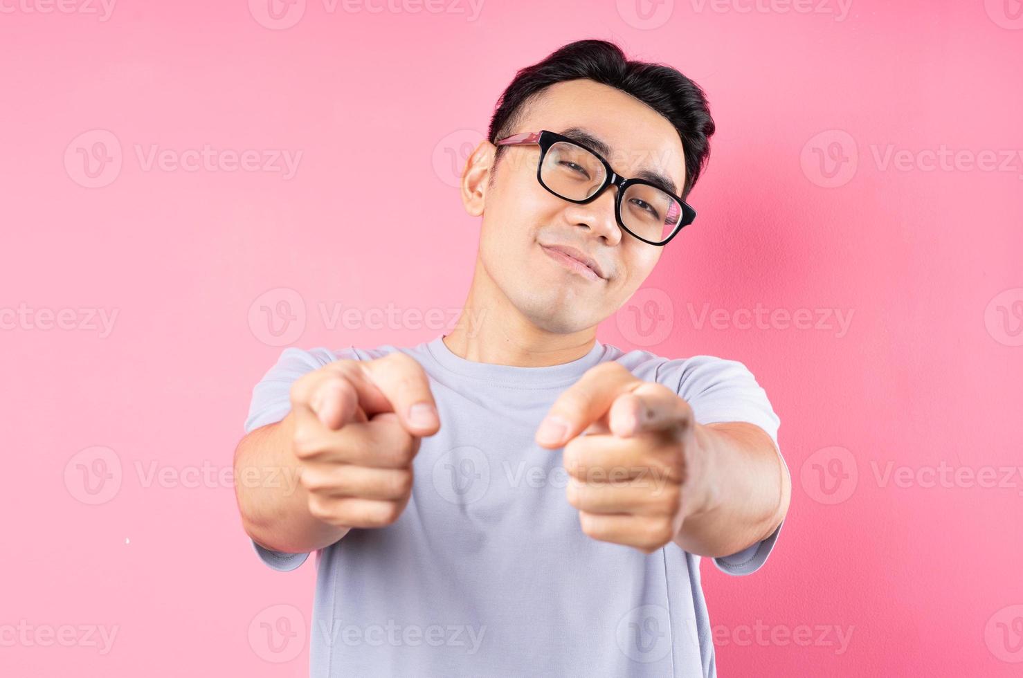 Retrato de hombre asiático posando sobre fondo rosa con muchas expresiones foto