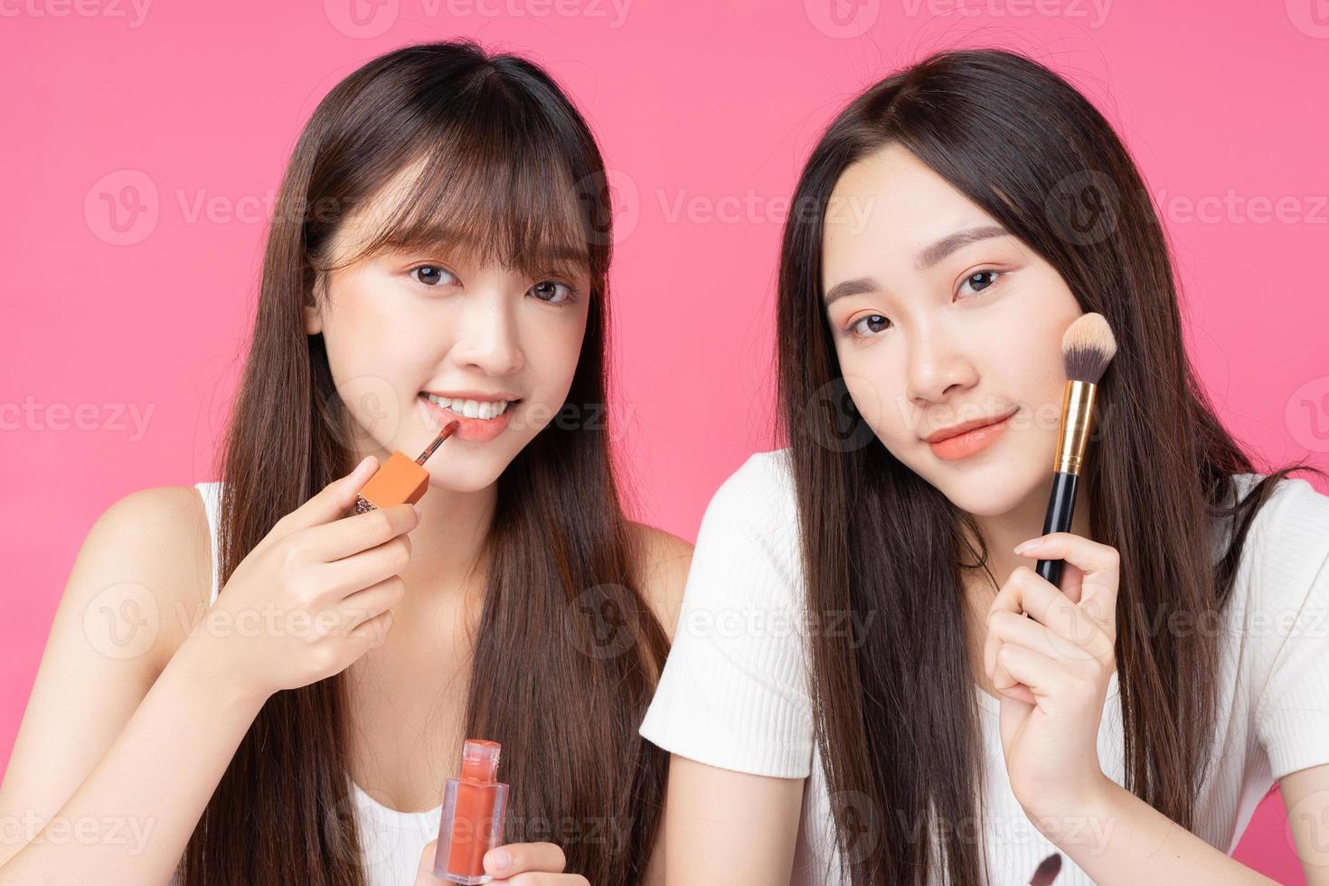 dos hermosas jovencitas asiáticas haciendo maquillaje el uno al otro foto