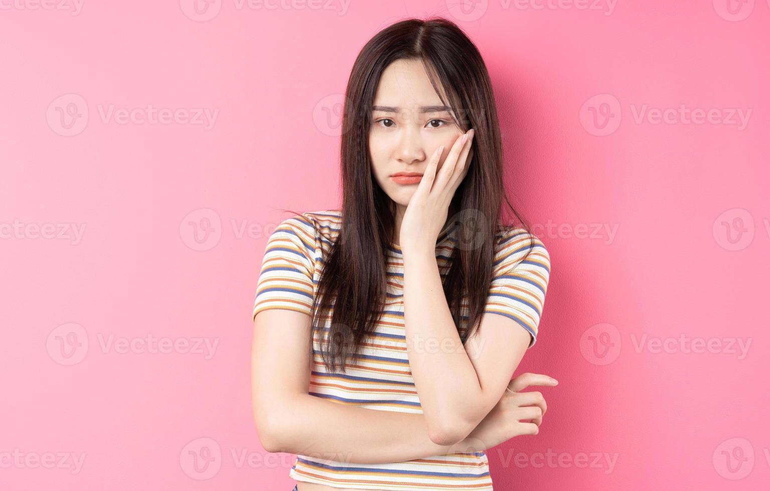 joven, mujer asiática, posar, en, fondo rosa foto