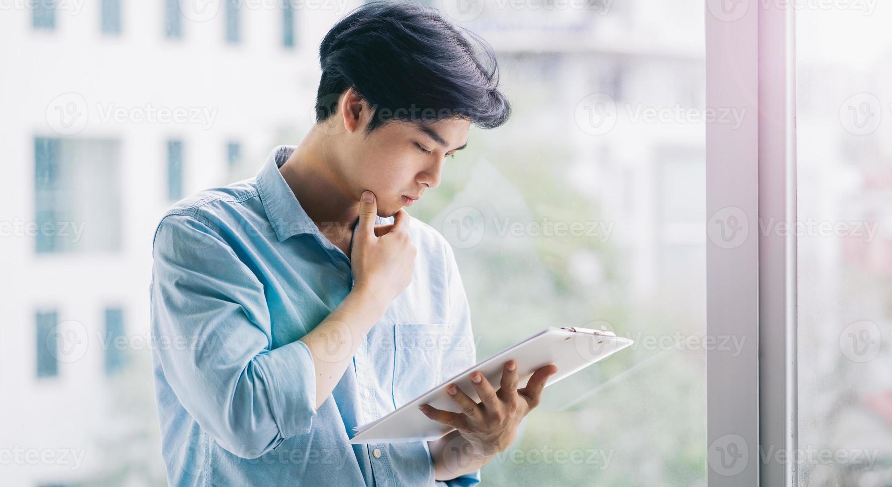 Retrato de un hombre de negocios asiático trabajando atentamente foto