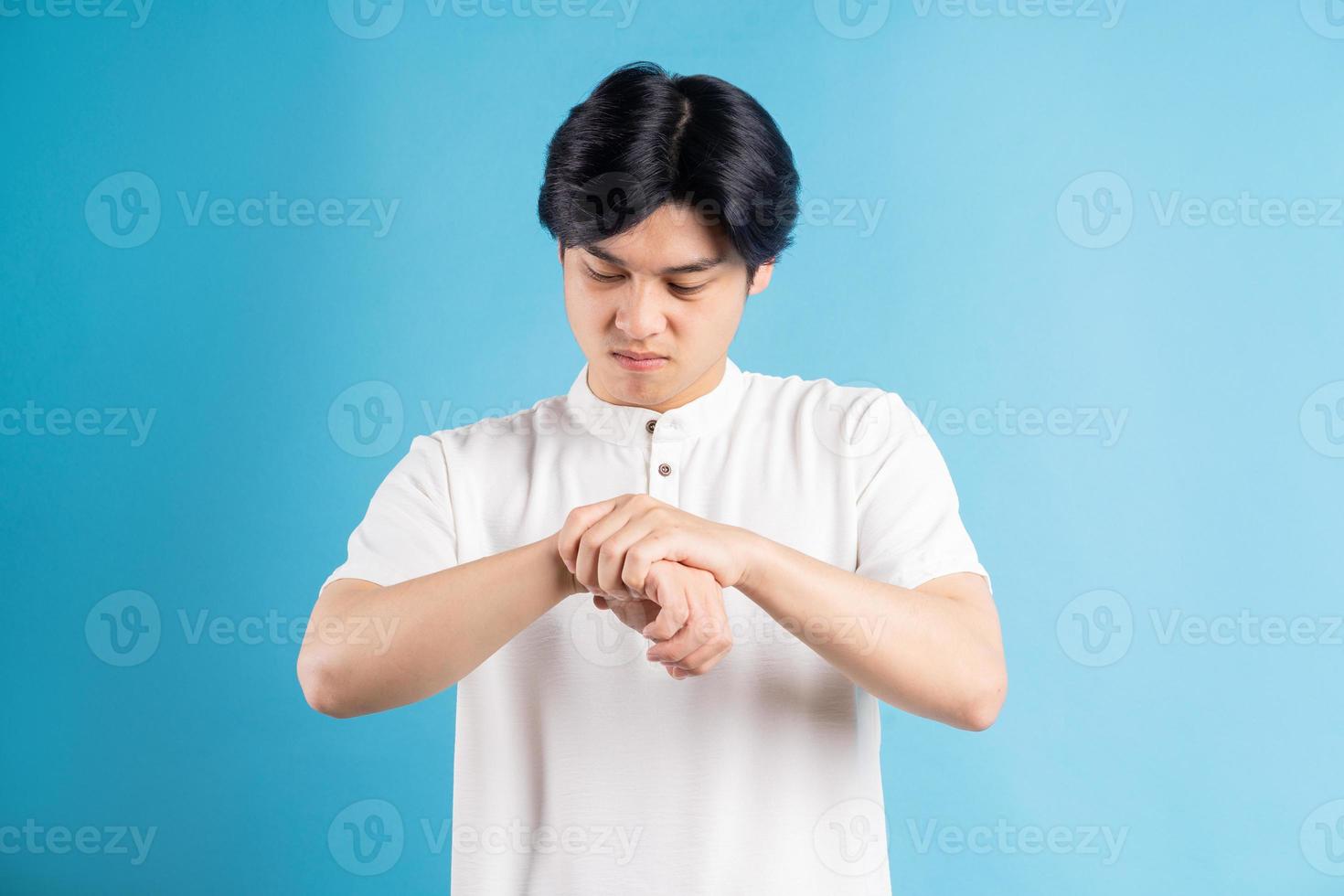 hombre asiático está molesto por el dolor de muñeca foto