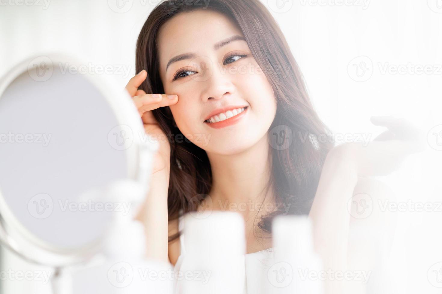 Asian woman sitting makeup in front of mirror photo