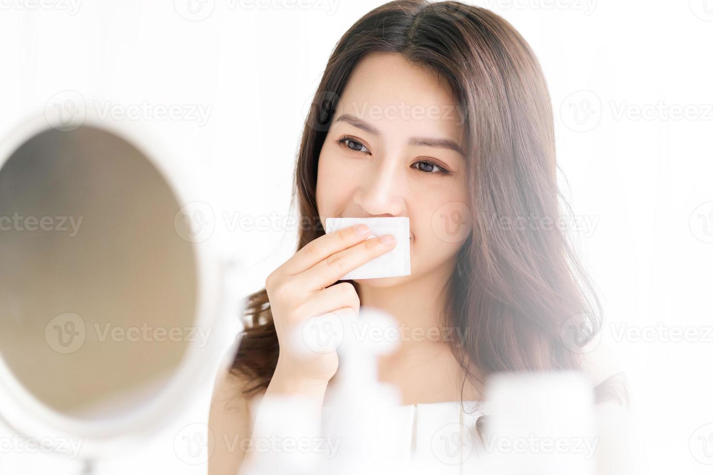 Asian woman sitting makeup in front of mirror photo