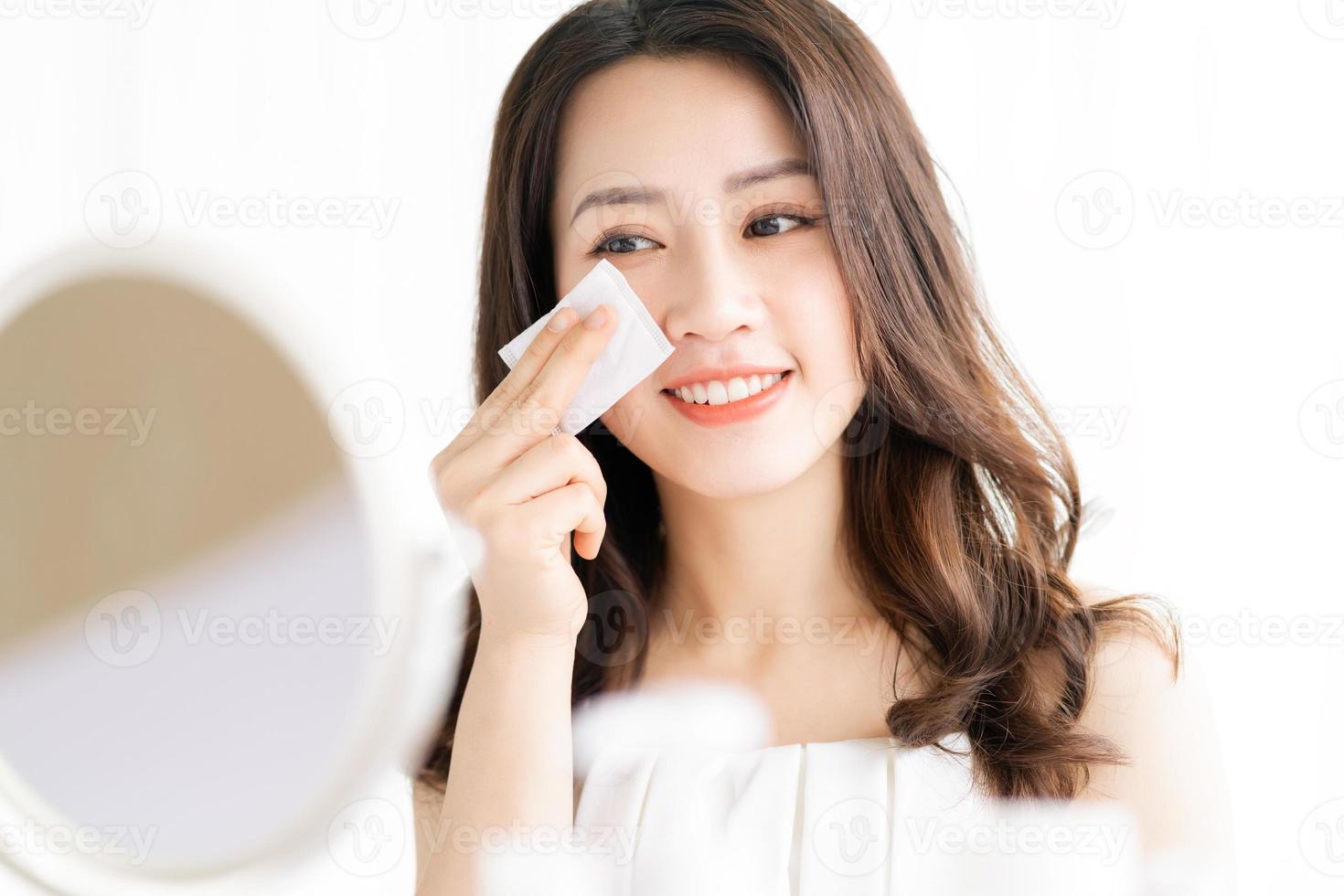 Asian woman sitting makeup in front of mirror photo