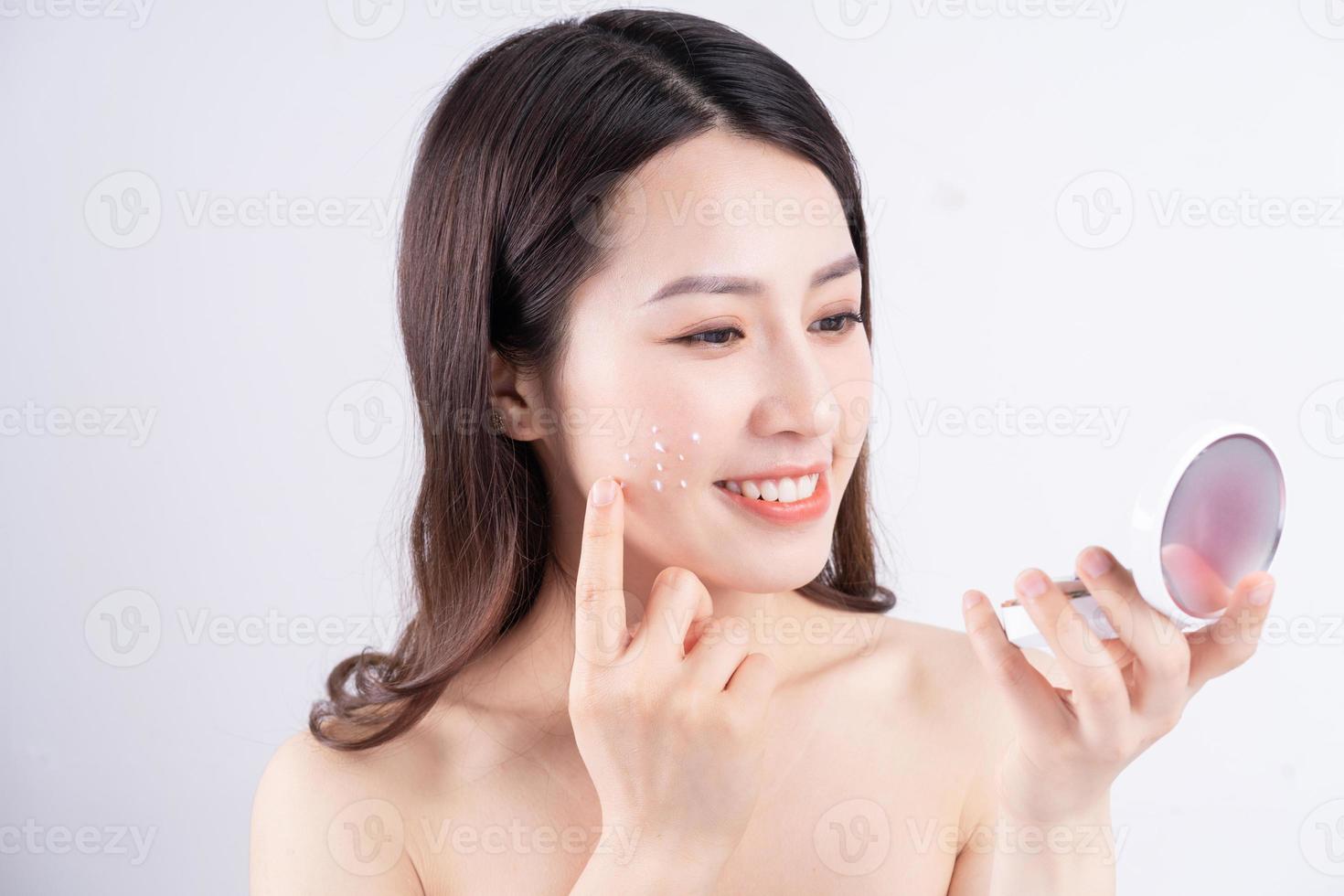 Young Asian girl with a happy expression sitting with cream on the background photo