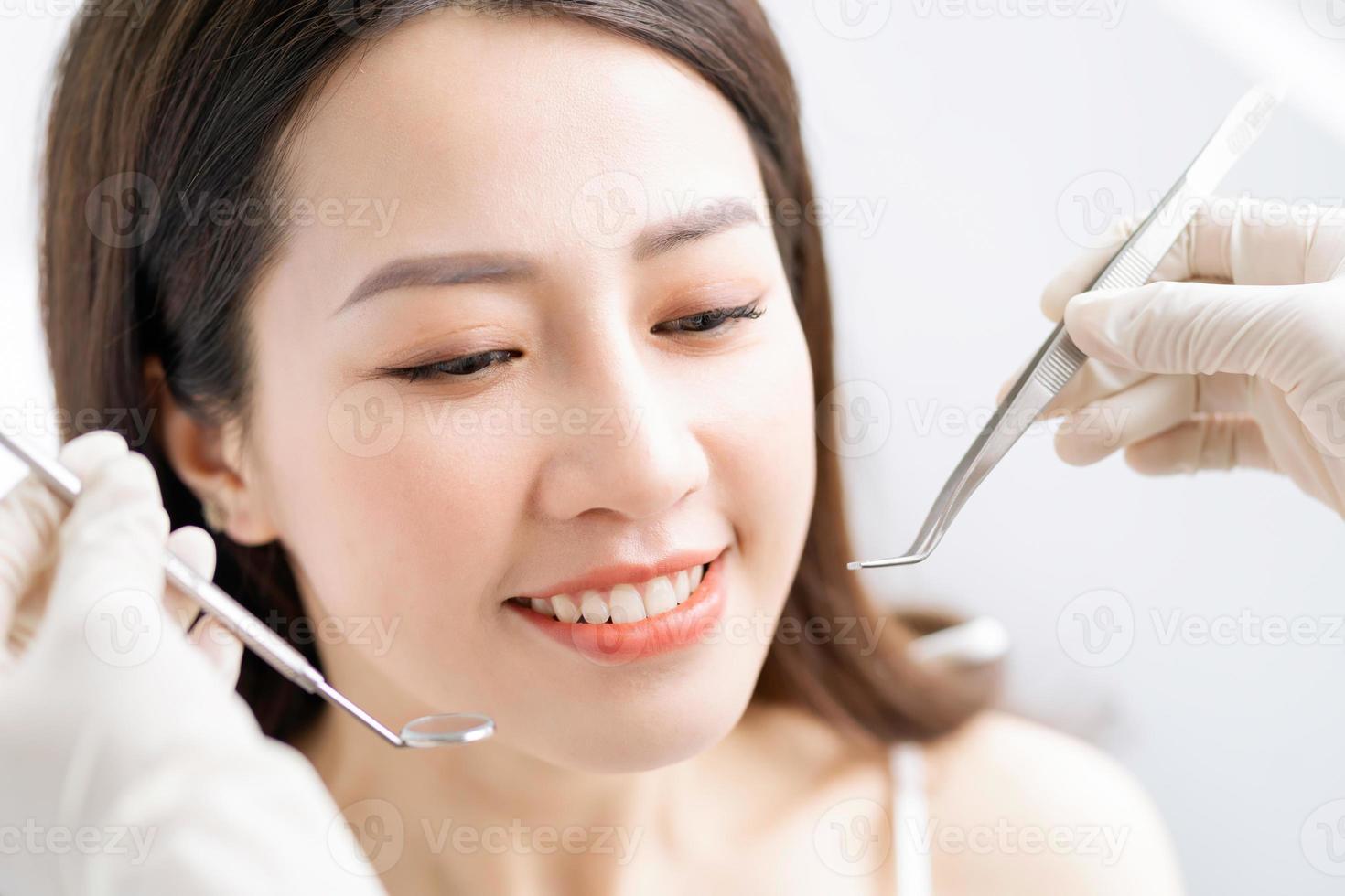 la mujer asiática está teniendo un examen dental de rutina en la clínica dental foto