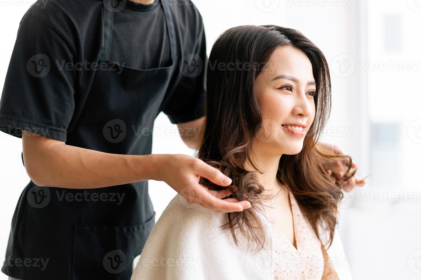 Mujer asiática con expresión feliz haciendo peluquería en salong foto