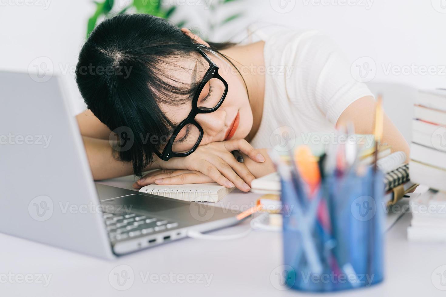 Asian businesswoman is tired and headache with a lot of work on the deadline photo