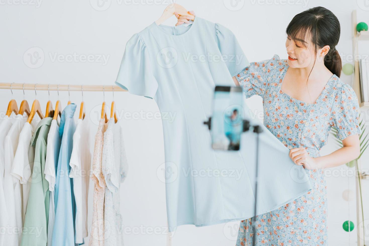 Young Asian beautiful woman is live streaming to sell clothes on social networking platforms and e-commerce sites. This will be the future trend of the ecommerce industry photo