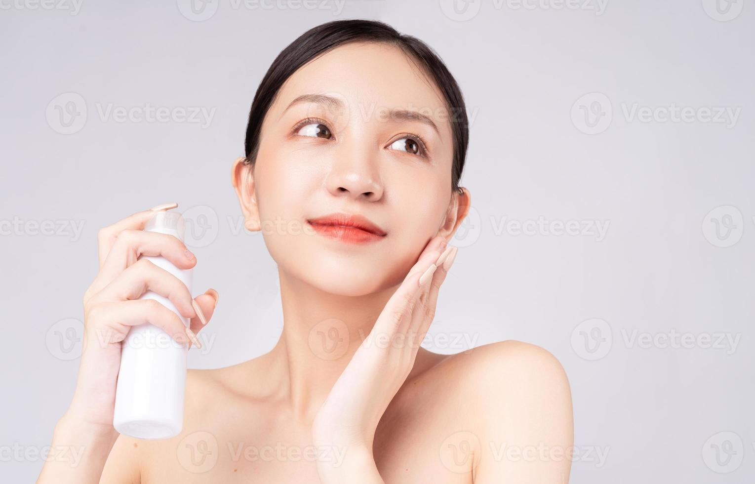 hermosa mujer asiática cuidando su piel con productos naturales foto