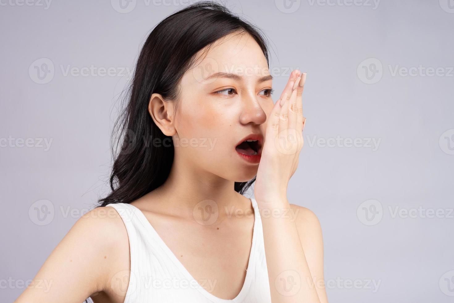 Asian woman feels uncomfortable because of bad breath photo