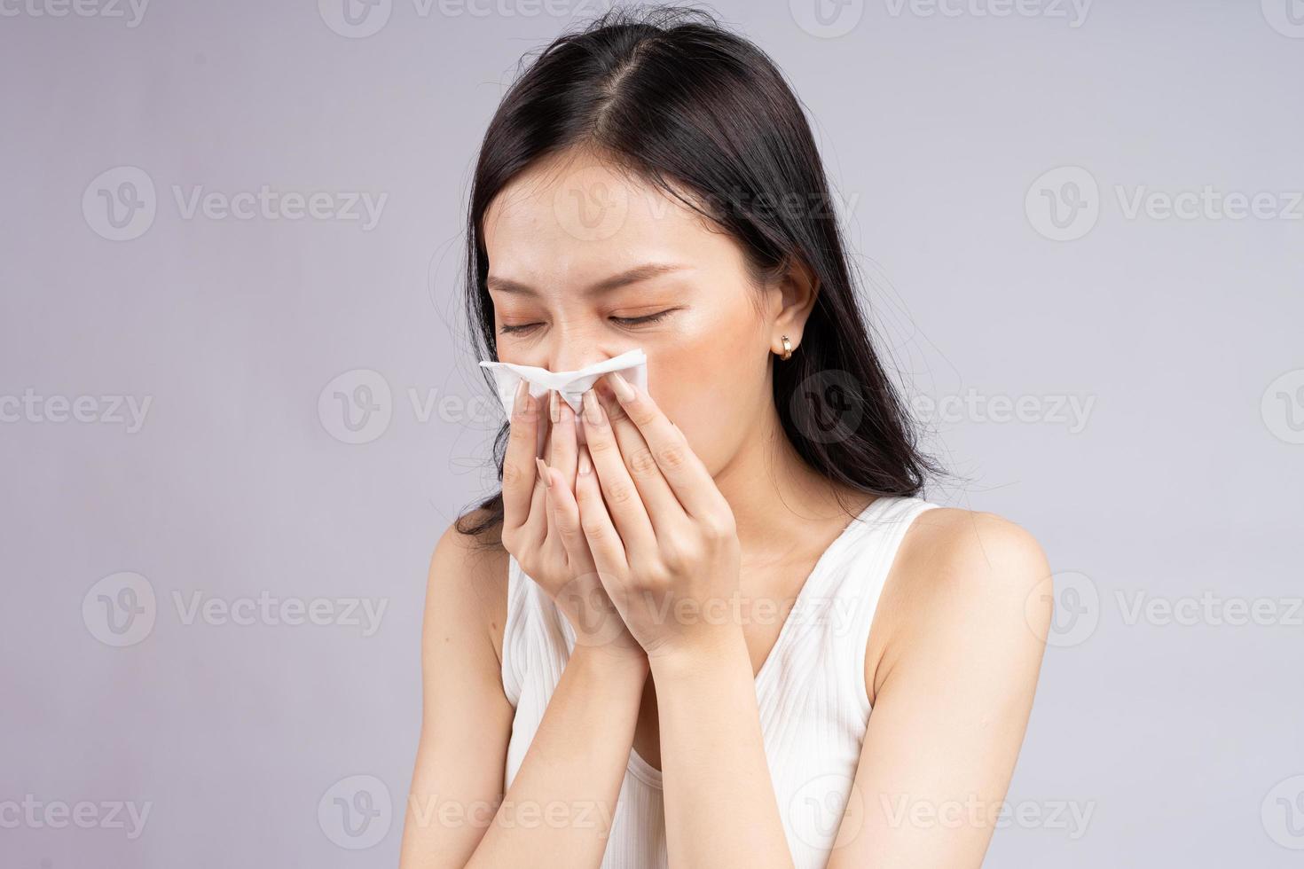 mujer asiática estornuda cuando tiene un resfriado foto