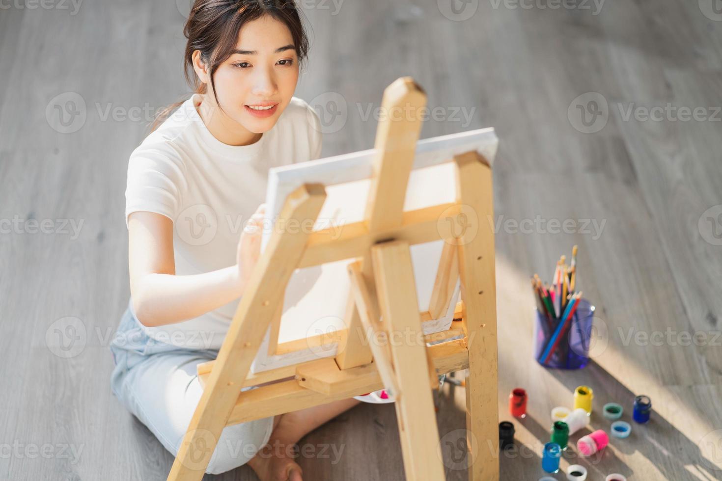 niña sentada en el suelo aprendiendo a dibujar sola foto