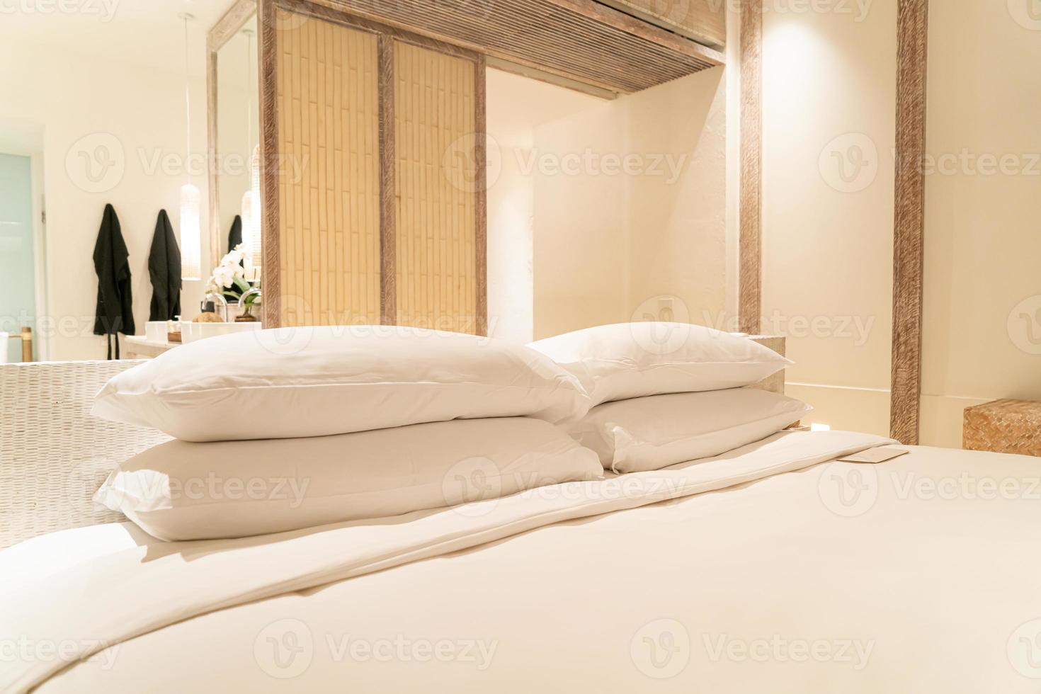 Decoración de almohadas blancas en la cama en el dormitorio del resort de hotel de lujo foto