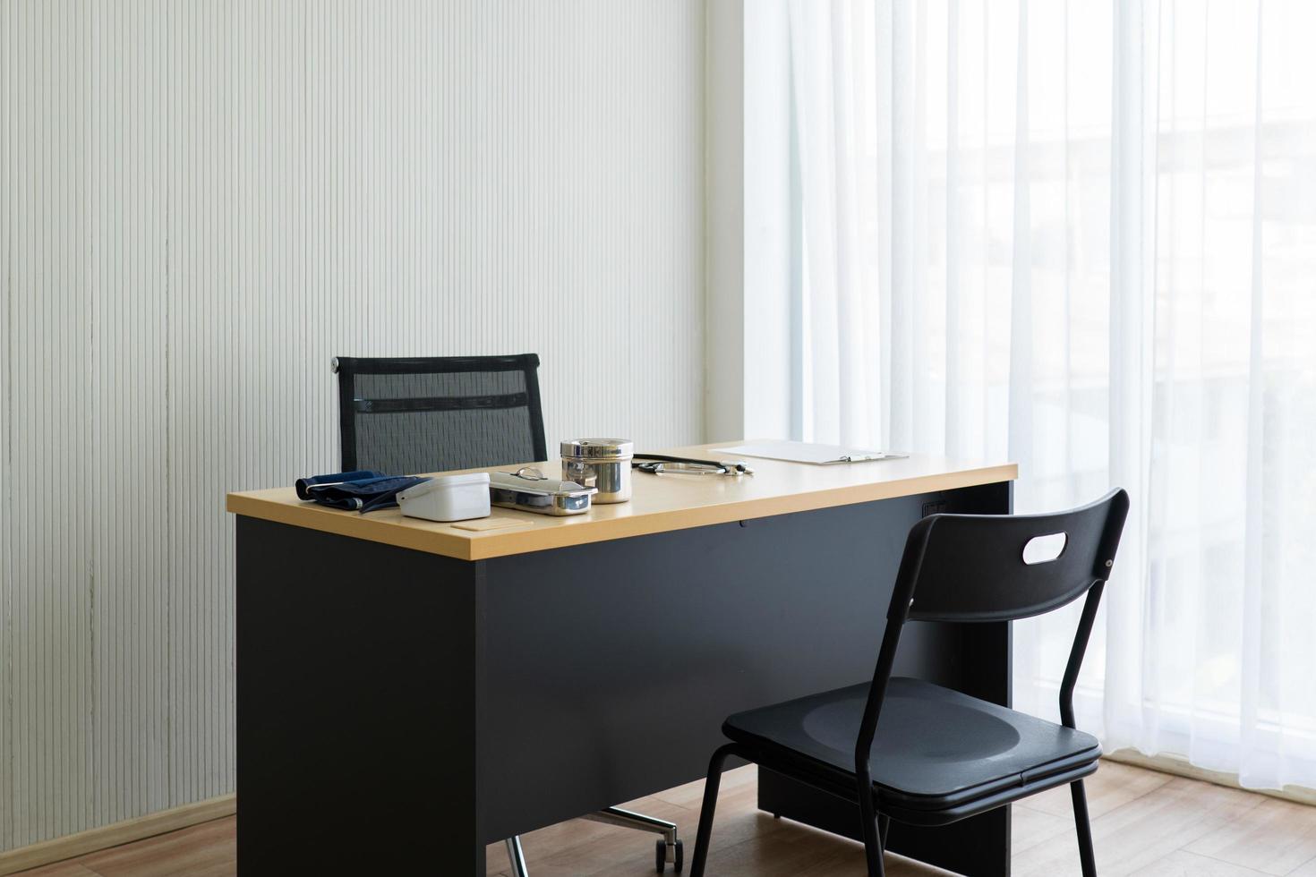 Picture of working desk of doctor in outpatient clinic in hospital including stethoscope and digital sphygmomanometer ready for patient visit. medical and healthcare concept photo