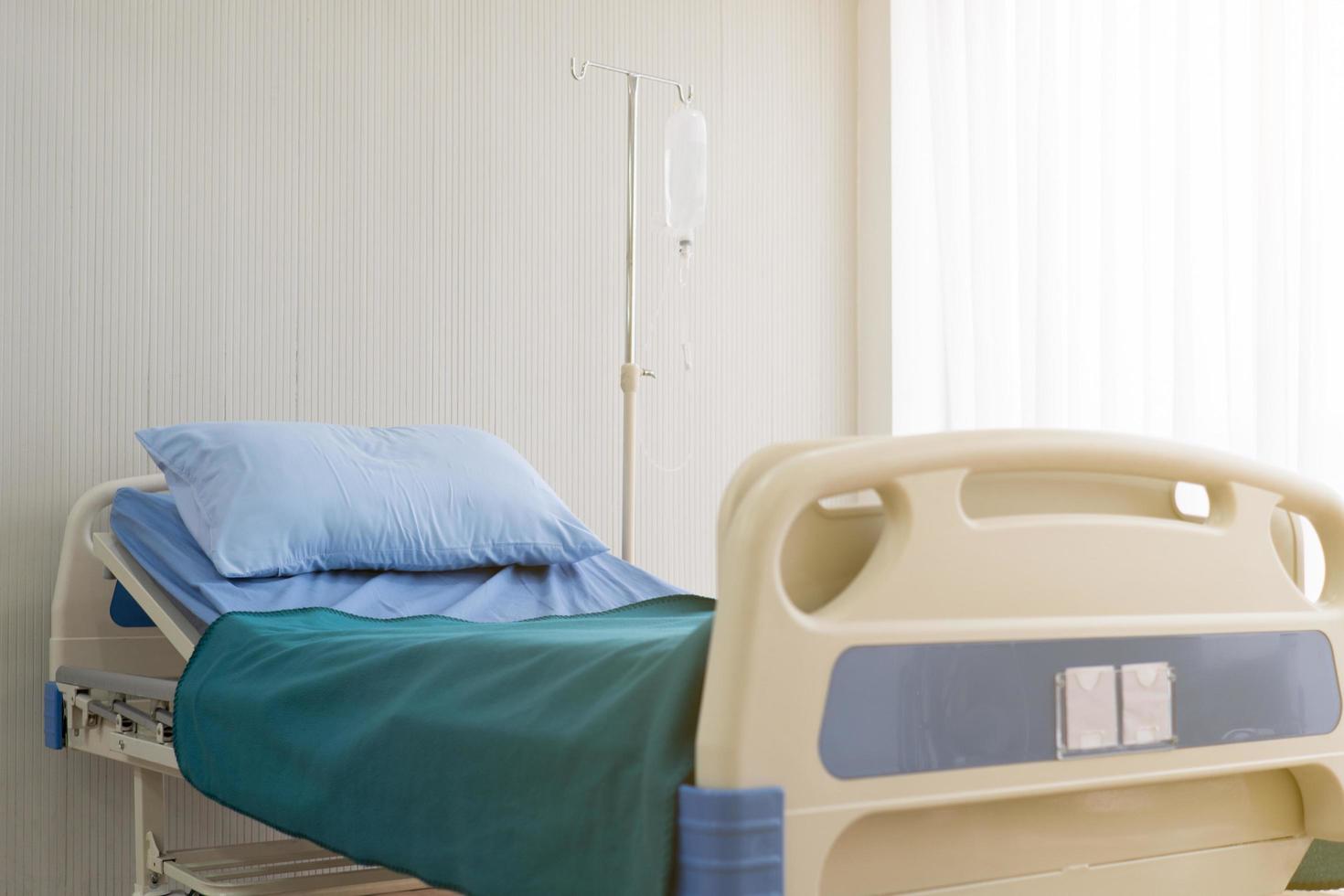 cama en la sala del hospital para que el paciente enfermo ingrese para recibir tratamiento. concepto médico y sanitario foto