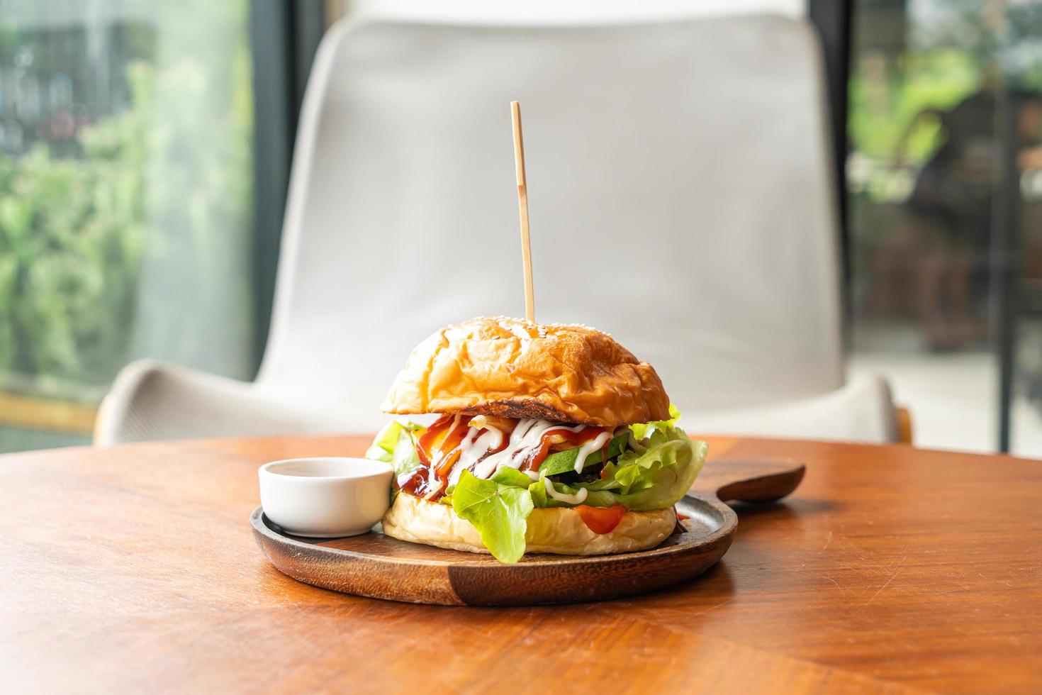 Beef burger with cheese and sauce on wood plate photo