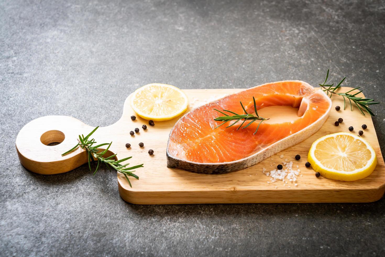 Filete de salmón crudo fresco con ingredientes a bordo foto