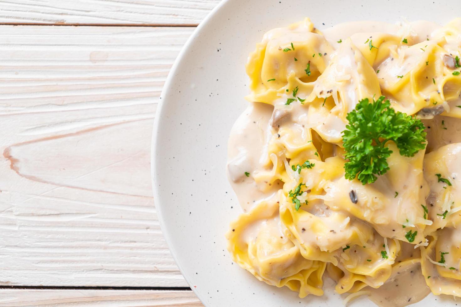 Pasta tortellini con salsa de crema de champiñones y queso - estilo de comida italiana foto