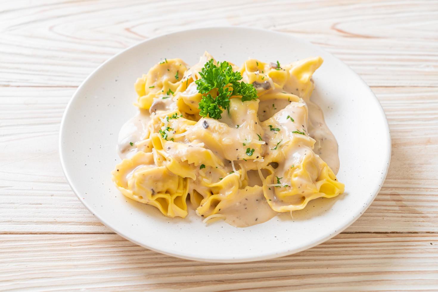 Tortellini pasta with mushroom cream sauce and cheese - Italian food style photo