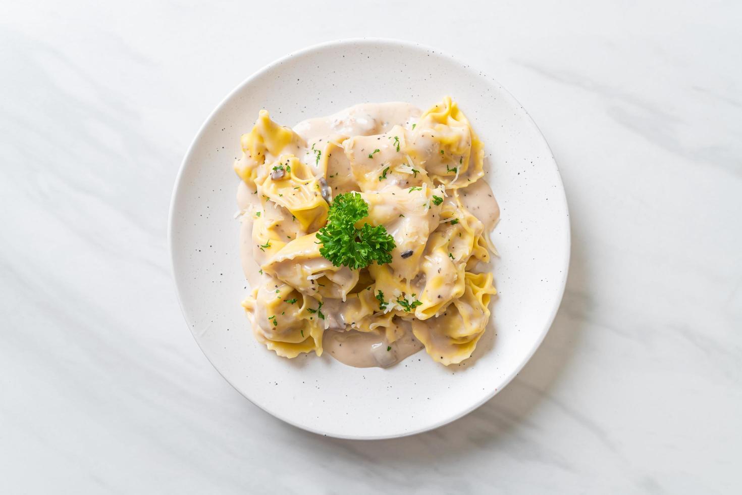 Tortellini pasta with mushroom cream sauce and cheese - Italian food style photo